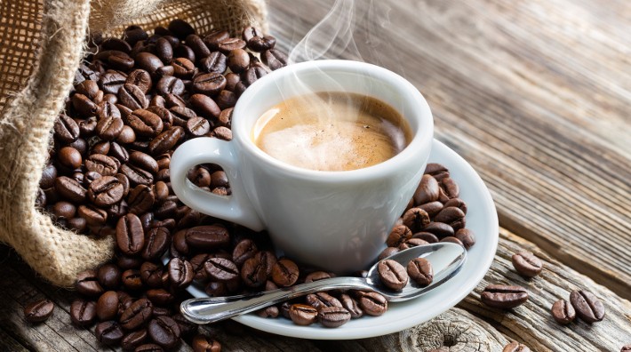 Кружечка с кофе, окруженная кофейными зернами